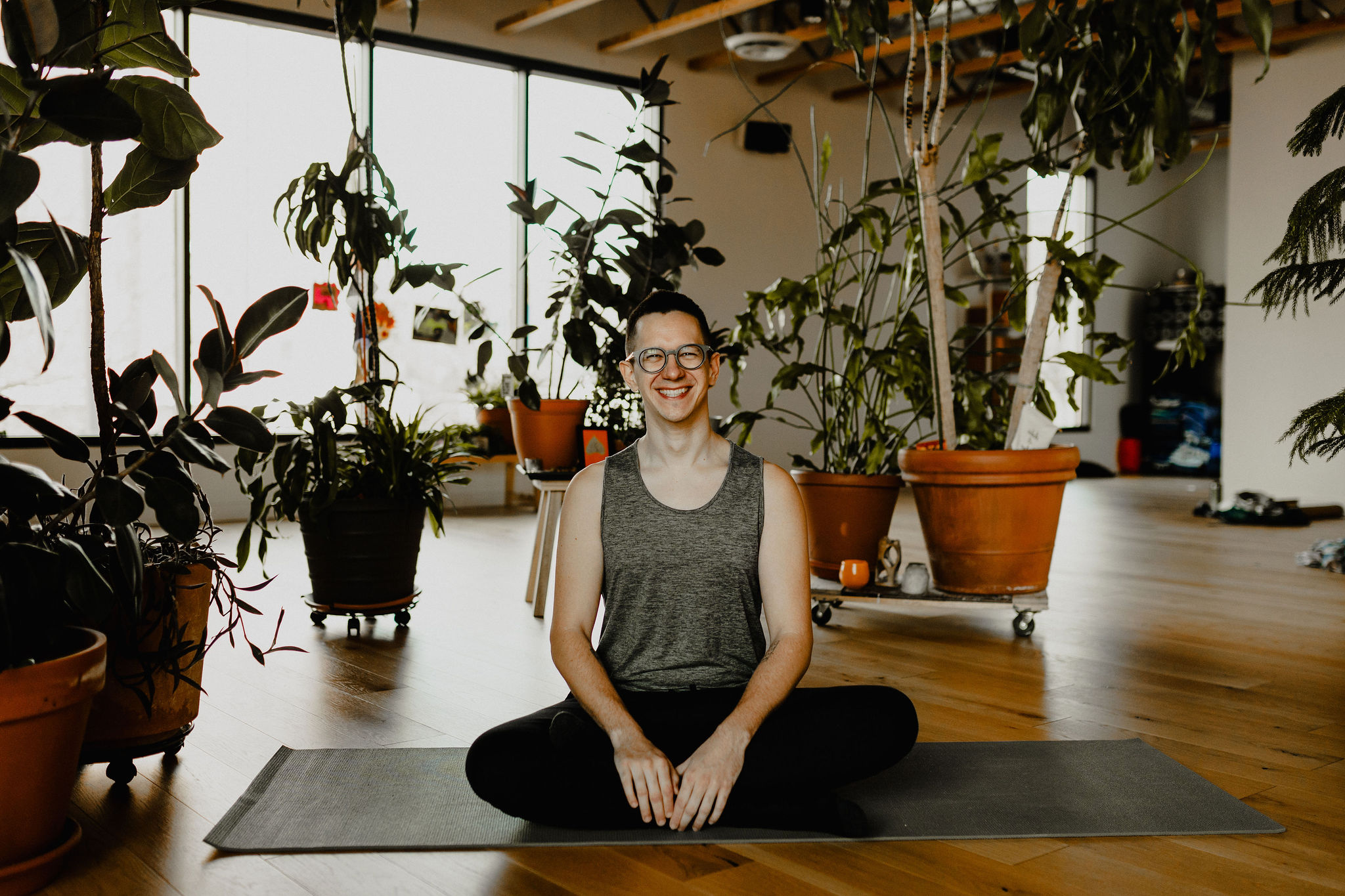 Josh smiling while sitting cross-legged on a yoga mat